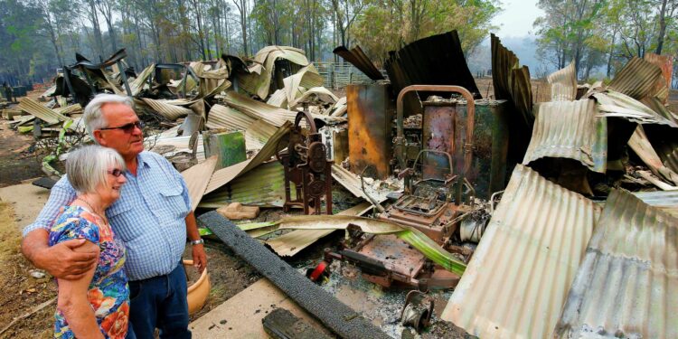 Lyn and Peter Iverson with their burnt out office and shed on their property at Half Chain road, Koorainghat, Australia, November 11, 2019. AAP Image/Darren Pateman/via REUTERS    ATTENTION EDITORS - THIS IMAGE WAS PROVIDED BY A THIRD PARTY. NO RESALES. NO ARCHIVE. AUSTRALIA OUT. NEW ZEALAND OUT.