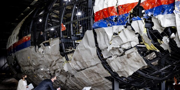 Trial judges and lawyers view the reconstructed wreckage of Malaysia Airlines Flight MH17, at the Gilze-Rijen military Airbase, southern Netherlands on May 26, 2021. - Judges inspect wreckage of flight MH17 as part of criminal trial of four suspects. (Photo by Sem van der Wal / ANP / AFP)