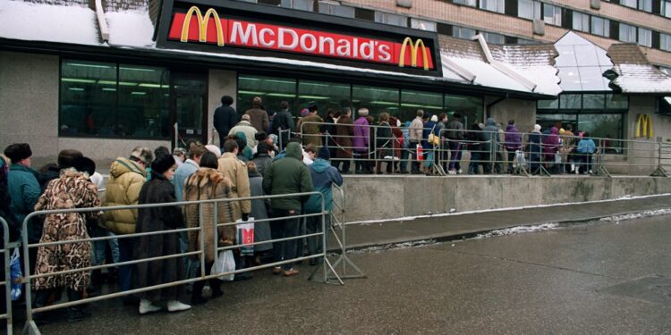 Des Moscovites font la queue, le 01 février 1992 à Moscou, devant l'enseigne de restauration rapide américaine, McDonald's. Pour faire face à la pénurie alimentaire, les Russes doivent attendre parfois jusqu'à deux à trois heures par jour devant les magasins. AFP PHOTO DIMA KOROTAYEN (Photo by DIMA KOROTAYEN / AFP)