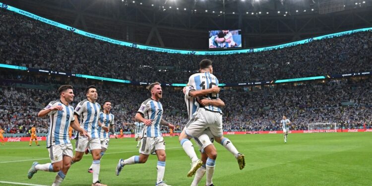 Argentina's defender #26 Nahuel Molina celebrates with Argentina's forward #10 Lionel Messi and teammates after scoring his team's first goal during the Qatar 2022 World Cup quarter-final football match between Netherlands and Argentina at Lusail Stadium, north of Doha, on December 9, 2022. (Photo by Alberto PIZZOLI / AFP)