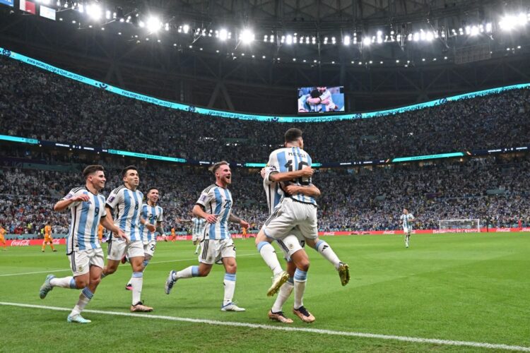 Argentina's defender #26 Nahuel Molina celebrates with Argentina's forward #10 Lionel Messi and teammates after scoring his team's first goal during the Qatar 2022 World Cup quarter-final football match between Netherlands and Argentina at Lusail Stadium, north of Doha, on December 9, 2022. (Photo by Alberto PIZZOLI / AFP)