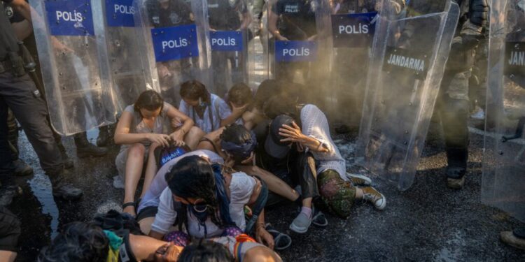 Protestors resist as Turkish soldiers of the Gendarmerie General Command and anti-riot police officers use water cannons and tear gas to push back demonstrators during clashes in Ikizkoy, in the Milas district of the Province of Mugla, on July 29, 2023. - Local residents and environmental activists demonstrate for the fifth day against the deforestation project of the 750-decare century-old pine forest, intended to expand a lignite field in the forests of Akbelen in Ikizkoy, leading to clashes with Turkish Gendarmerie. (Photo by BULENT KILIC / AFP)