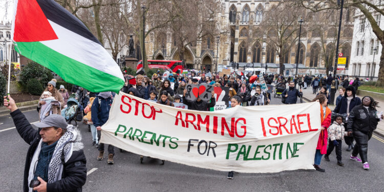 Parents and children march from Westminster Abbey to the Foreign Office during a multifaith 'Christmas Is Cancelled In Palestine' event organised by Parents For Palestine to highlight the plight of Palestinian children in Gaza on 22nd December 2023 in London, United Kingdom. Parents for Palestine, who prepared handmade rubble and sang adapted Christmas carols, called on British politicians to demand an immediate ceasefire in Gaza and the cessation of arms sales to Israel. (photo by Mark Kerrison/In Pictures via Getty Images)