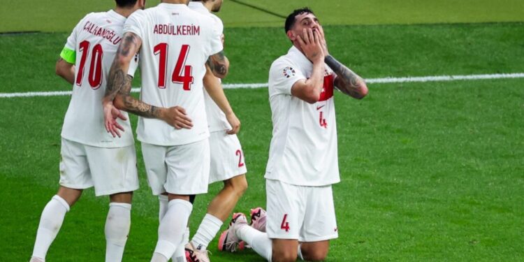 Turkey's defender #04 Samet Akaydin celebrates with teammates after scoring his team's first goal during the UEFA Euro 2024 quarter-final football match between the Netherlands and Turkey at the Olympiastadion Berlin in Berlin on July 6, 2024. (Photo by Ronny HARTMANN / AFP)