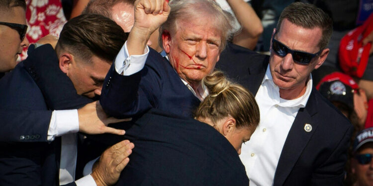 Republican candidate Donald Trump is seen with blood on his face surrounded by secret service agents as he is taken off the stage at a campaign event at Butler Farm Show Inc. in Butler, Pennsylvania, July 13, 2024. - Donald Trump was hit in the ear in an apparent assassination attempt by a gunman at a campaign rally on Saturday, in a chaotic and shocking incident that will fuel fears of instability ahead of the 2024 US presidential election.
The 78-year-old former president was rushed off stage with blood smeared across his face after the shooting in Butler, Pennsylvania, while the gunman and a bystander were killed and two spectators critically injured. (Photo by Rebecca DROKE / AFP)