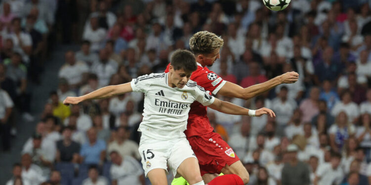 Real Madrid's Turkish midfielder #15 Arda Guler and Stuttgart's German midfielder #16 Atakan Karazor jump for the ball during the UEFA Champions League 1st round day 1 football match between Real Madrid CF and Stuttgart VFB at the Santiago Bernabeu stadium in Madrid on September 17, 2024. (Photo by Pierre-Philippe MARCOU / AFP)