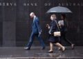 Pedestrians walks past the Reserve Bank of Australia in Sydney on June 4, 2019. - The Reserve Bank cut interest rates by 25 basis points to a historic low of 1.25 percent, as the pace of growth slowed to levels not seen since the global financial crisis. (Photo by PETER PARKS / AFP)