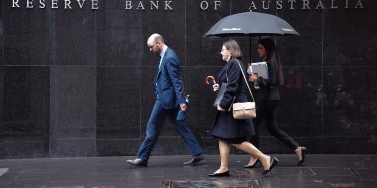 Pedestrians walks past the Reserve Bank of Australia in Sydney on June 4, 2019. - The Reserve Bank cut interest rates by 25 basis points to a historic low of 1.25 percent, as the pace of growth slowed to levels not seen since the global financial crisis. (Photo by PETER PARKS / AFP)