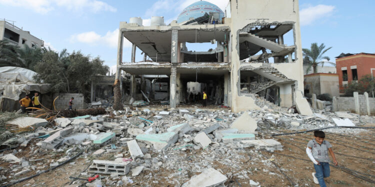 Palestinians inspect the site of an Israeli strike on a mosque sheltering displaced people, amid Israel-Hamas conflict, in Deir Al-Balah, in the central Gaza Strip, October 6, 2024. REUTERS/Ramadan Abed