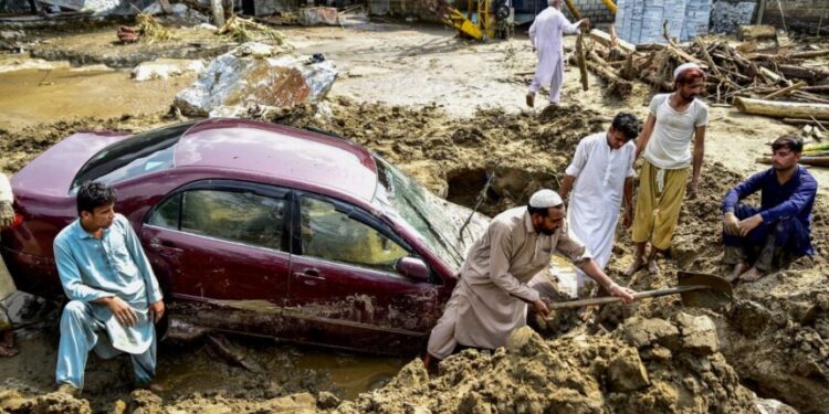 People struggle to retrieve a car from mud and debris after flash floods in the Buner district of the monsoon-hit northern Pakistan's mountainous Khyber Pakhtunkhwa province on August 16, 2025. Rescuers were struggling to retrieve bodies from debris after flash floods triggered by heavy monsoon rains across northern Pakistan killed at least 321 people in the past 48 hours, authorities said on August 16. (Photo by Hasham AHMED / AFP)