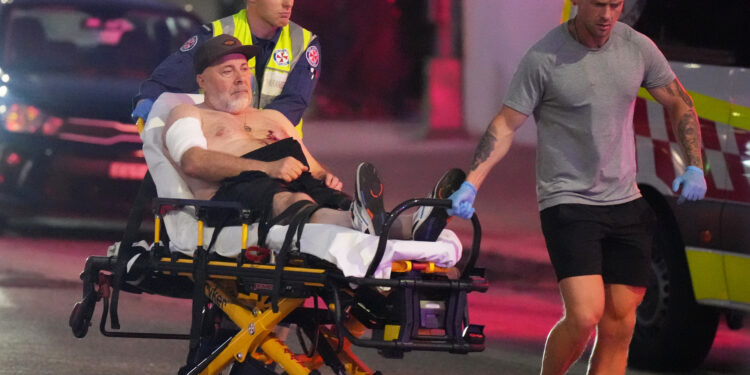 Emergency workers transport a person on a stretcher after a reported shooting at Bondi Beach in Sydney, Sunday, Dec. 14, 2025. (AP Photo/Mark Baker)