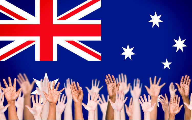 Multiethnic Arms Raised and Australian Flag Background