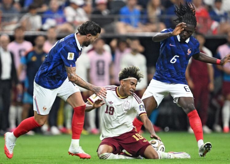 Spain's forward #19 Lamine Yamal (C) fights for the ball with France's defender #19 Theo Hernandez (L) and France's midfielder #06 Manu Kone during the 2026 World Cup football tournament semi-final match between France and Spain at the Dallas Stadium in Arlington on July 14, 2026.  (Photo by MAURO PIMENTEL / AFP)