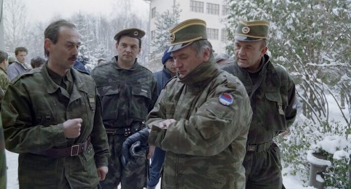 (FILES) Bosnian Serb General Ratko Mladic (2R) checks his watch at the Lukavica barracks in the surburbs of Sarajevo on February 15, 1994. Former Bosnian military Serb leader and war criminal Ratko Mladic has died in a prison hopsital in the Hague, according to Serbian state broadcaster RTS on August 27, 2026, after suffering several strokes. Mladic, 84, was dubbed the "Butcher of Bosnia" for his role in the 1995 Srebrenica massacre during the Bosnian war. (Photo by Pascal GUYOT / AFP)