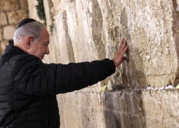 Israel's Prime Minister Benjamin Netanyahu prays as he visits the Western Wall -- the holiest site where Jews are allowed to pray -- to mark the swearing-in of the 37th government of Israel, in the old city of Jerusalem on January 1, 2023. (Photo by GIL COHEN-MAGEN / various sources / AFP)